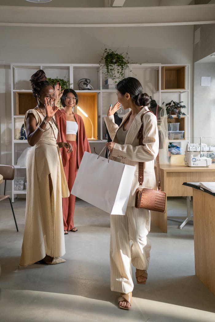Three women enjoying a shopping experience in a stylish fashion studio.